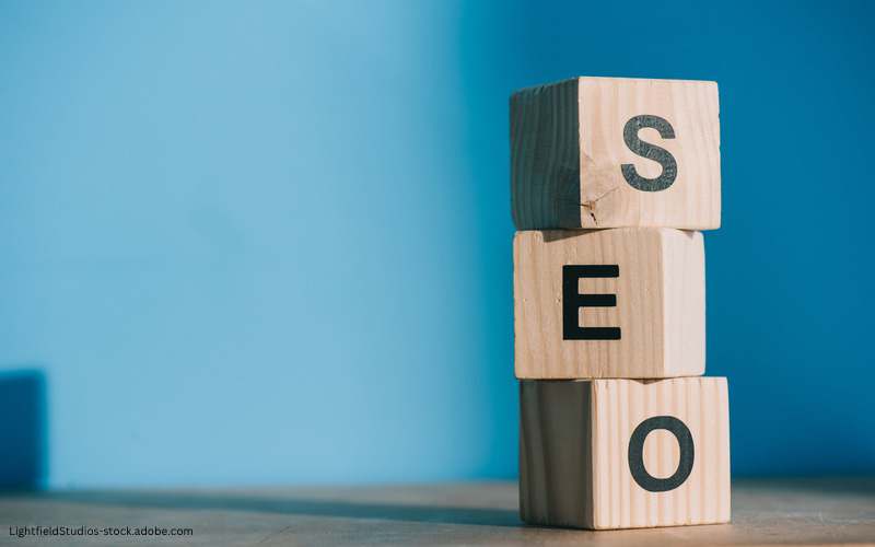 Drei übereinander gestapelte Holzwürfel bilden das Wort SEO