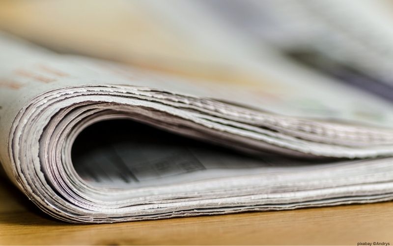 eine zusammengefaltete Zeitung auf einem Tisch liegend